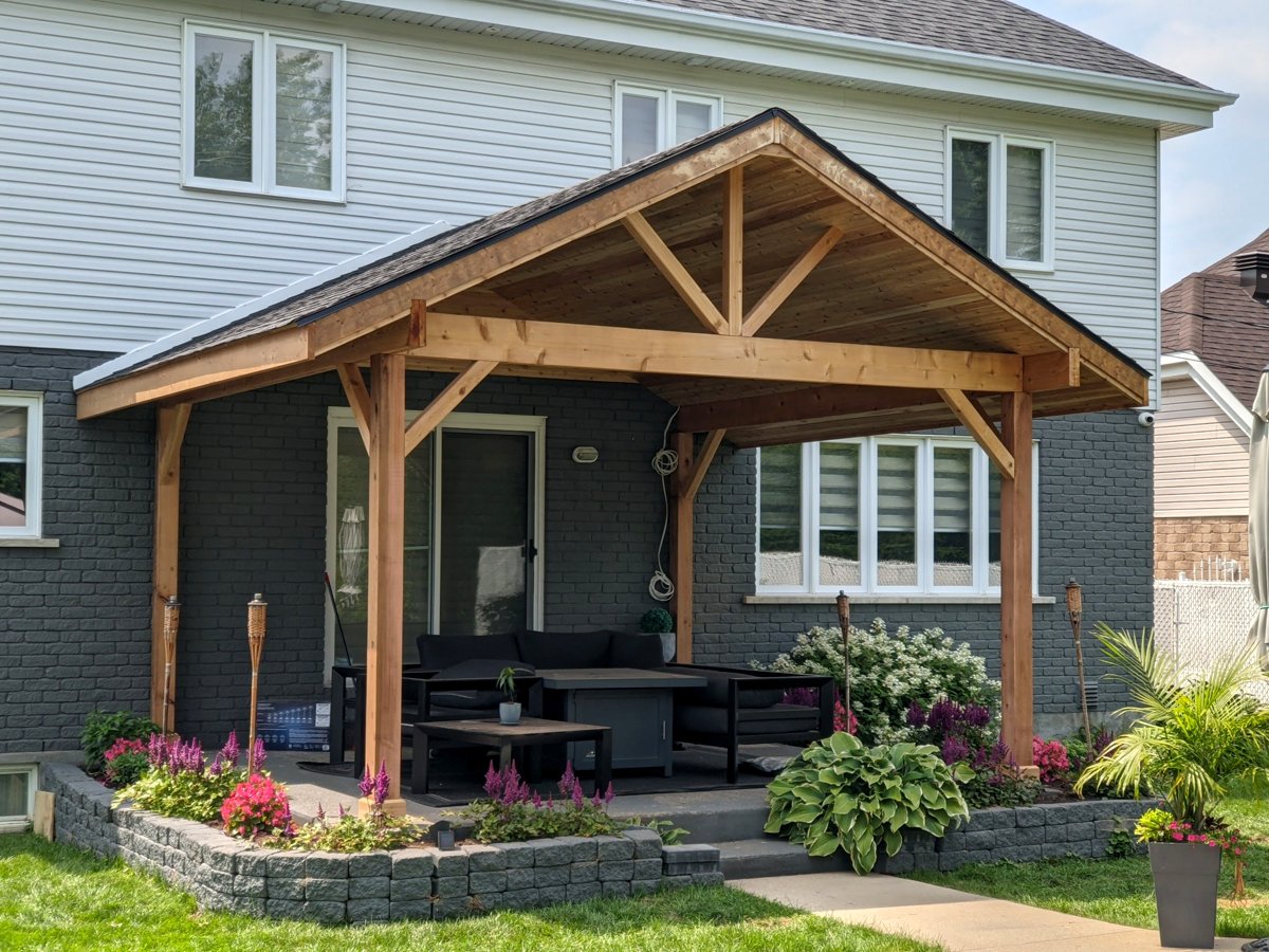 Cedar gable pergola over a backyard patio with stone planters